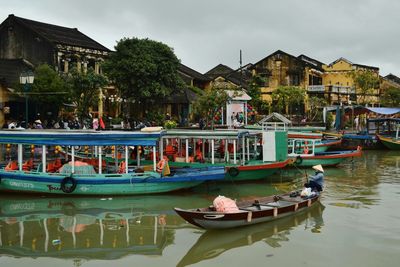 Boats in canal against buildings