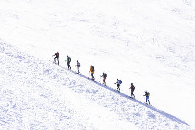 People skiing on snow covered landscape