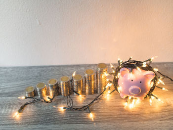 Close-up of illuminated lighting equipment on table against wall