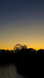 Scenic view of silhouette trees against clear sky during sunset