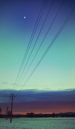 Electricity pylon against sky at sunset