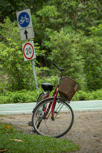 Bicycle sign on road against trees
