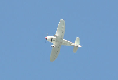 Low angle view of airplane against blue sky