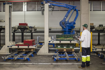 Worker checking machine progress using control panel