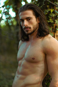 Portrait of young man standing in forest