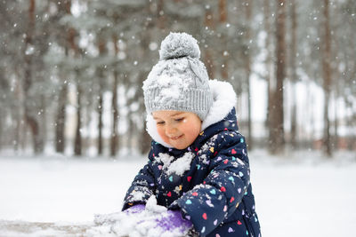 Child outdoors playing in snow. snowy winter weather.