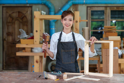 Portrait of beautiful asian woman carpenter dealing with handicraft