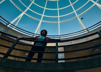 Low angle view of man in building against sky