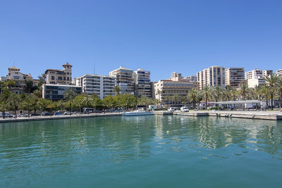 Buildings in city against clear blue sky