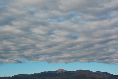 Low angle view of mountain against cloudy sky