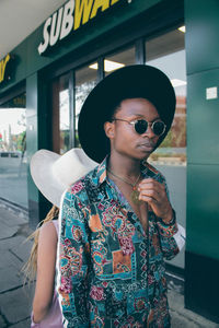 Young woman wearing sunglasses standing outdoors