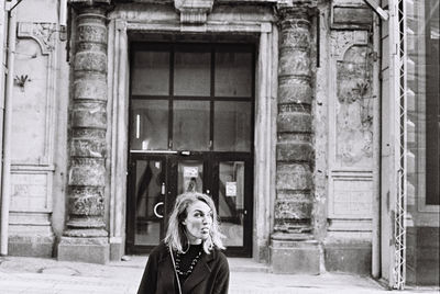 Portrait of woman standing at entrance of building