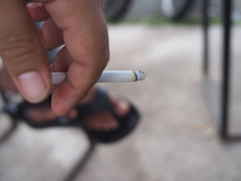 Close-up of hand holding cigarette