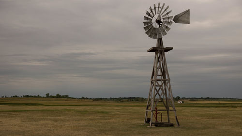 Traditional windmill on field against sky