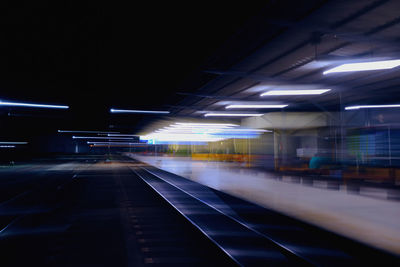 Illuminated railroad station platform at night