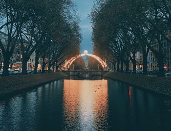 Bridge over river in city against sky