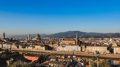 Illuminated cityscape against clear blue sky