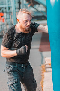 Young man practicing boxing in health club