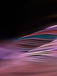 Close-up of colorful light trails against black background