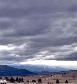 Scenic view of mountains against cloudy sky