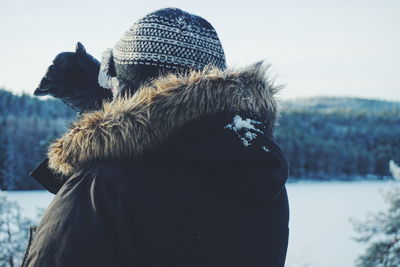 Close-up of person wearing hat while standing on field during winter