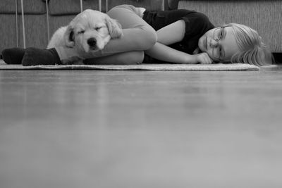 Girl and dog resting on floor at home