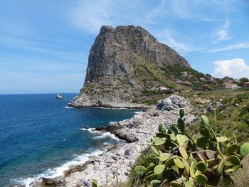 Rock formation in sea against sky