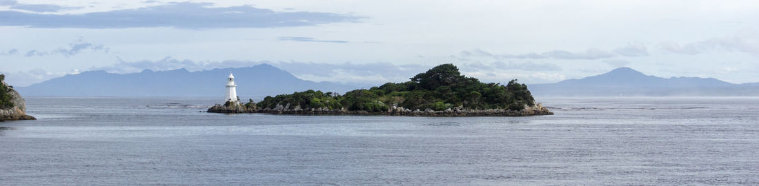 Scenic view of sea and mountains against sky