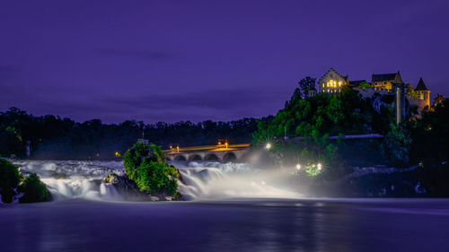 Scenic view of waterfall against sky at night