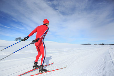 Man skiing on snowcapped mountain against sky