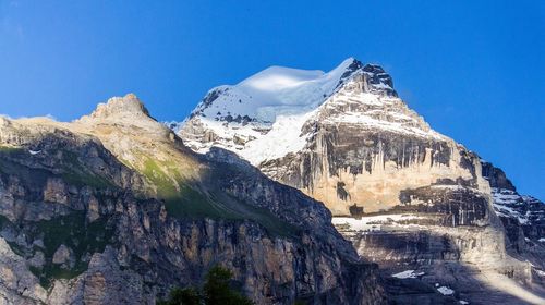 Scenic view of snowcapped mountains against clear blue sky