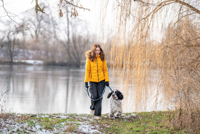 Rear view of woman standing on puddle