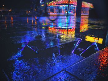 Wet illuminated street during rainy season at night