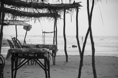 Close-up of chairs on beach against sky