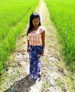 Full length of young woman standing on field