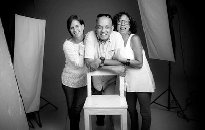 Portrait of smiling family in studio shot standing by reflectors