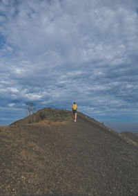 Rear view of man on shore against sky