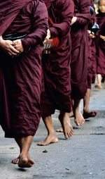 Low section of monks walking on street