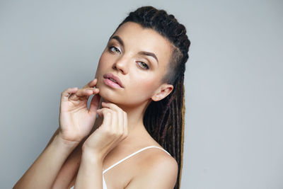 Portrait of young woman against white background