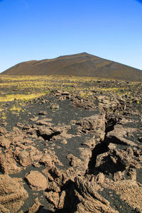 Scenic view of desert against clear blue sky