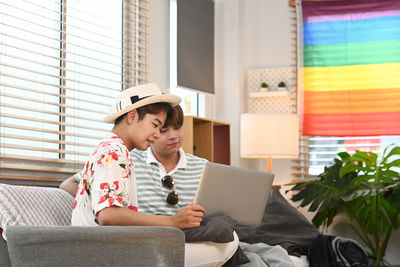 Boy using laptop while sitting on sofa at home