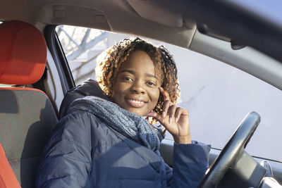 Portrait of smiling woman sitting in car