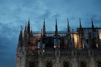 Low angle view of milan cathedral against cloudy sky at dusk