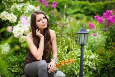 Portrait of beautiful woman sitting at park