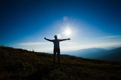 Man with arms outstretched standing on land