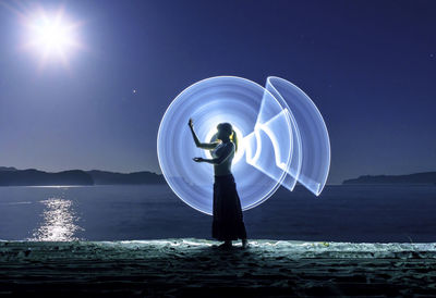 Man standing by sea against clear blue sky