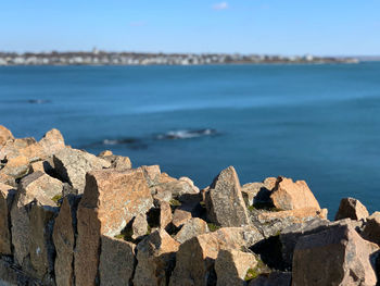 Rocks on shore by sea against sky at newport rhode island 