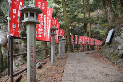 Red text on stone wall by trees in forest