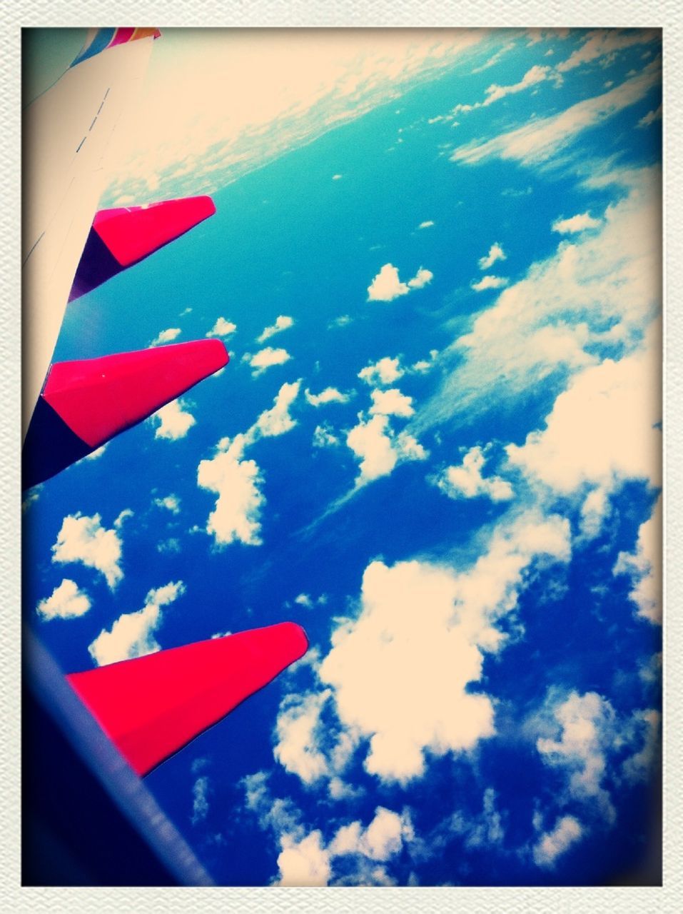 transfer print, transportation, mode of transport, auto post production filter, sky, flag, flying, airplane, air vehicle, aircraft wing, blue, part of, travel, cloud - sky, day, patriotism, red, nautical vessel, journey, cloud
