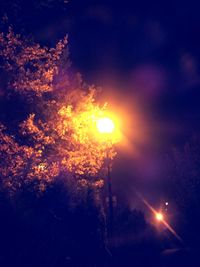 Low angle view of illuminated street light against sky